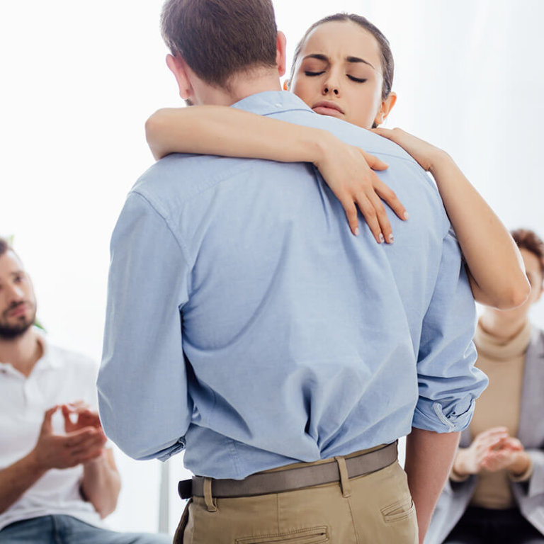 addiction treatment therapy in florida man and woman embrace during group addiction treatment therapy in florida