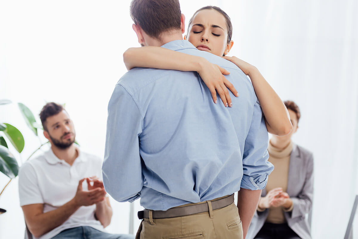 addiction treatment therapy in florida man and woman embrace during group addiction treatment therapy in florida